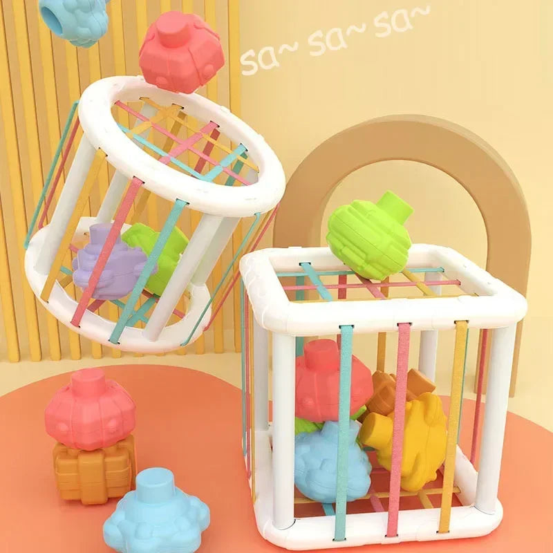 Cube sensoriel Montessori coloré pour bébé avec formes souples et bandes élastiques éducatives.